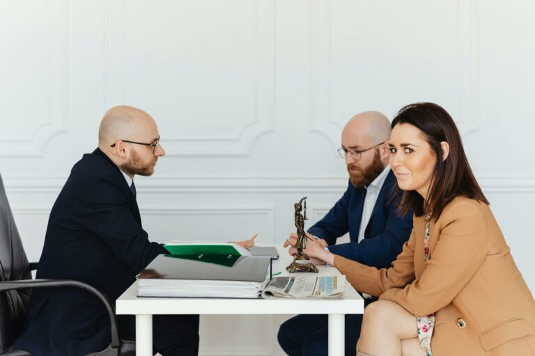 A lawyer consulting a couple in an elegant office setting, focusing on legal matters.