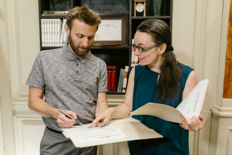 Two adults reviewing documents during a legal consultation in an office setting.