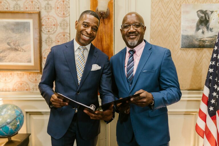 Two businessmen holding documents in an office, symbolizing professionalism and collaboration.